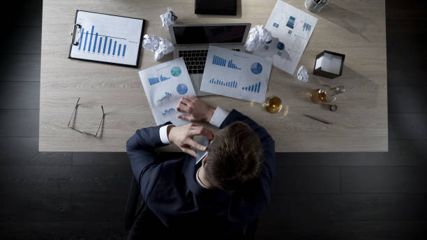 istock Businessman drinking alcohol and talking over phone, hard working day, top view 951480954