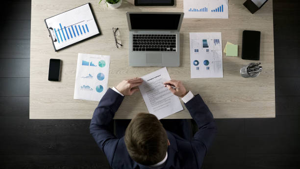 istock Man reading business contract, concluding agreement with partner, top view 951481124