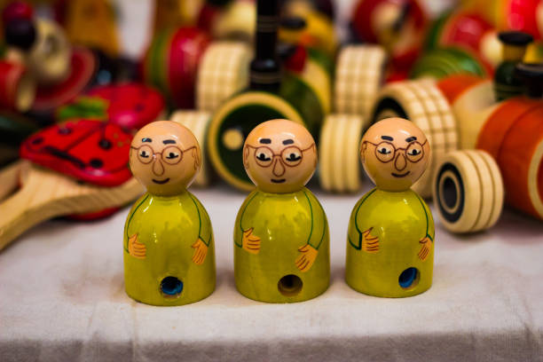 wooden three yellow dressed bald doll with spectacles. Gandhi model