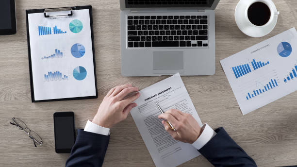 istock Rich male reading and learning purchase agreement in office, business, top view 951481446