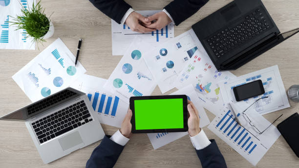 istock Man holding tablet with green screen, showing company presentation to partner 951483778