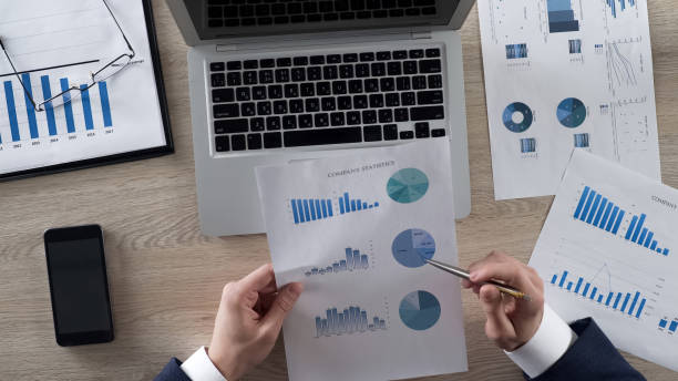 istock Business man analyzing company statistics comparing it with data on laptop 951483988