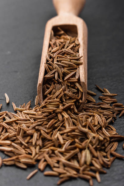 istock Seeds of cumin on a dark stone background 951485042