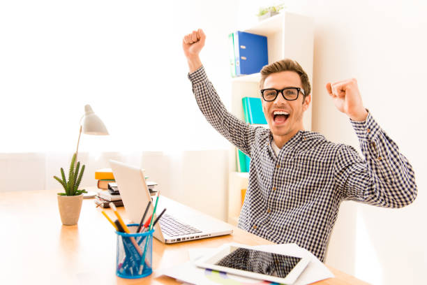 istock Portrait of happy successful young worker with raised hands 951490628