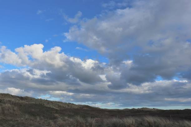 istock Fluffy white clouds in blue sky beside beach 951491314