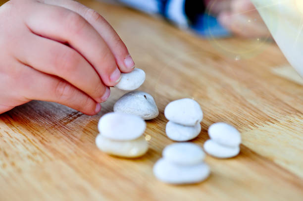istock hand building Stone tower on wooden table. 951499290