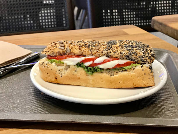 mozzarella-sandwich in poppy seed brot mit tablett serviert. - mozzarella tomato sandwich picnic stock-fotos und bilder