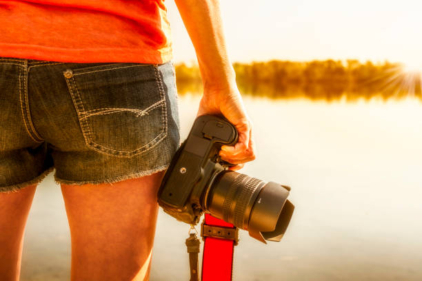 istock woman with camera taking pictures on a lake 951509980