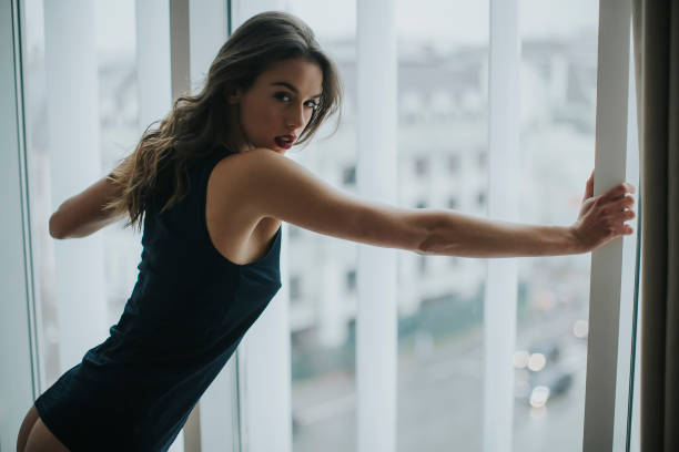 istock Pretty young woman by the window 951513926