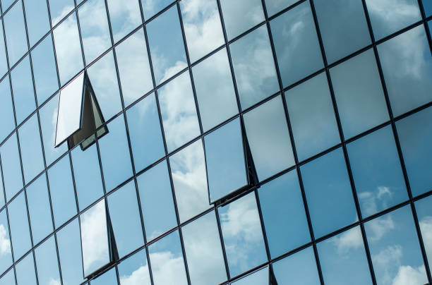istock modern building with glass reflection of clouds 951517466