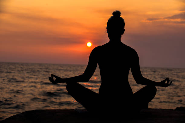 istock Young woman practicing yoga on the beach. 951534876