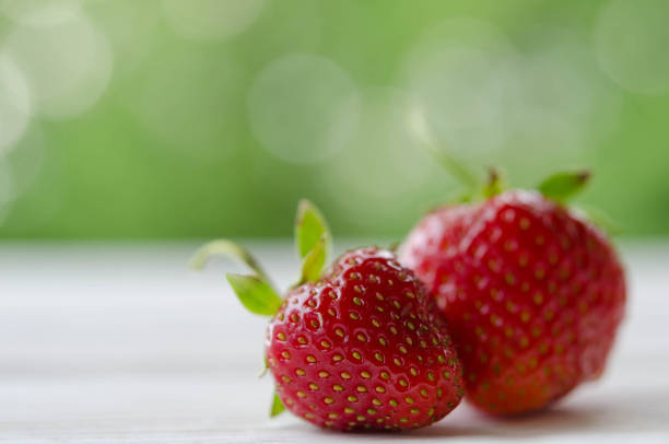 istock two strawberries on a wooden table 951539258