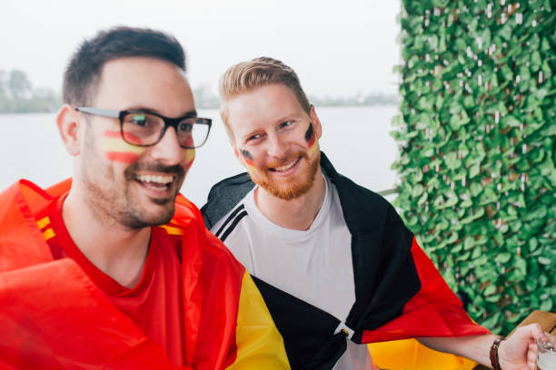 istock German soccer team supporter smiling at his friend supporting Spanish team 951539372