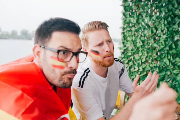 istock Serious soccer enthusiasts watching a game while wearing national flags and having face paint flags 951539404