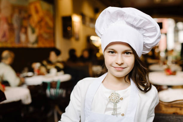 istock Cute girl in a white cap is a chef's chef 951540322