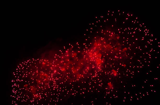 Fireworks and smoke in red color against a black sky as background.
