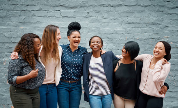 Happiness happens when we stand together Portrait of a diverse group of young women standing together against a gray wall outside group of people laughing stock pictures, royalty-free photos & images