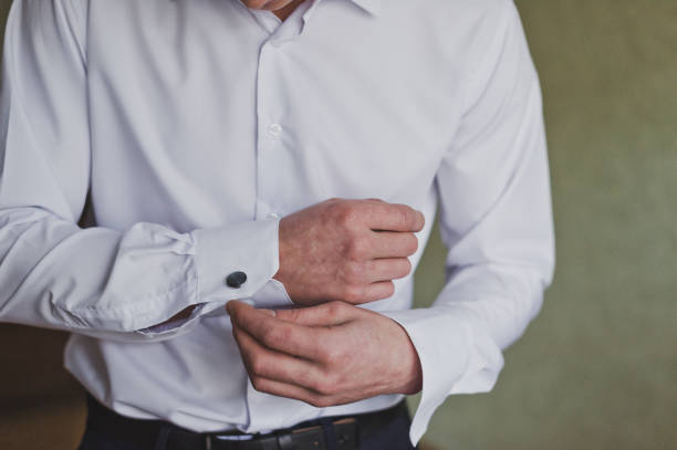 istock The process of buttoning a white shirt sleeve by a man 1181. 951542174
