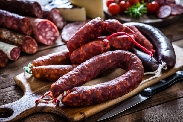 istock Mixed spanish chorizo pieces on rustic wooden table 951546246