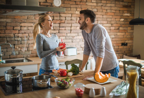 istock Happy couple communicating while preparing healthy lunch in the kitchen. 951550170
