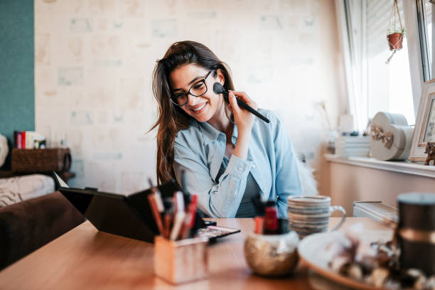 Confident girl doing make-up in her house.
