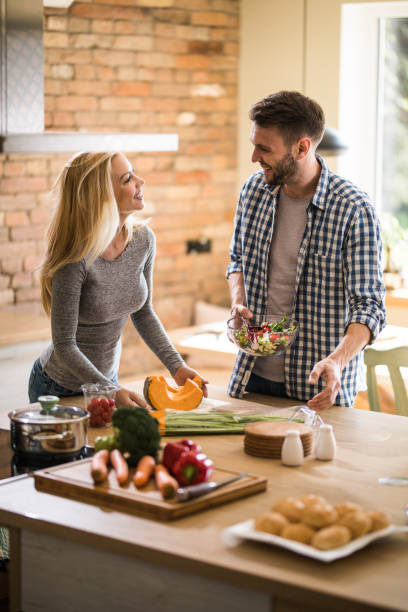 istock Young happy couple talking while preparing healthy meal in the kitchen. 951552030