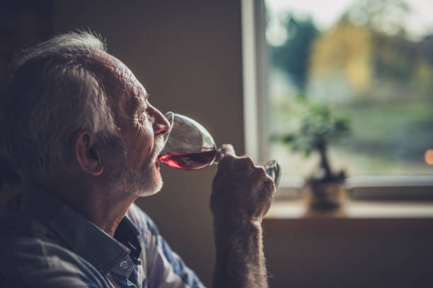 istock Profile view of a senior man drinking wine at home. 951571222