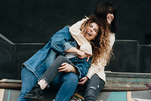Two beautiful caucasian girls having fun laughing embracing.