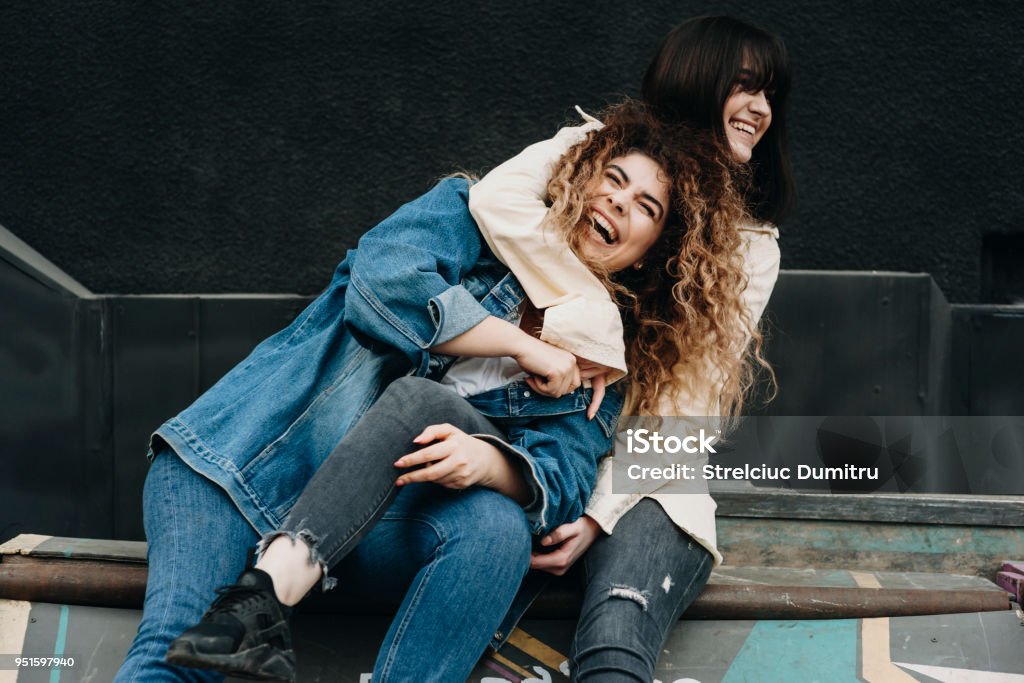 Two beautiful caucasian girls having fun laughing embracing. Sister Stock Photo