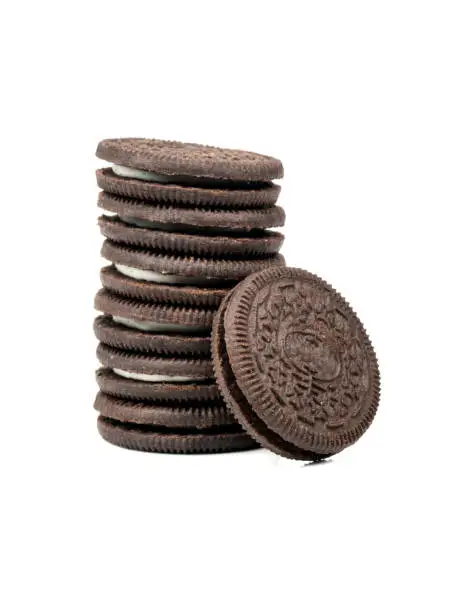 Stack of black cookies with cream on white background