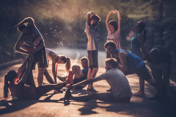 istock Marathon runners stretching while warming up before the race at sunset. 951630356