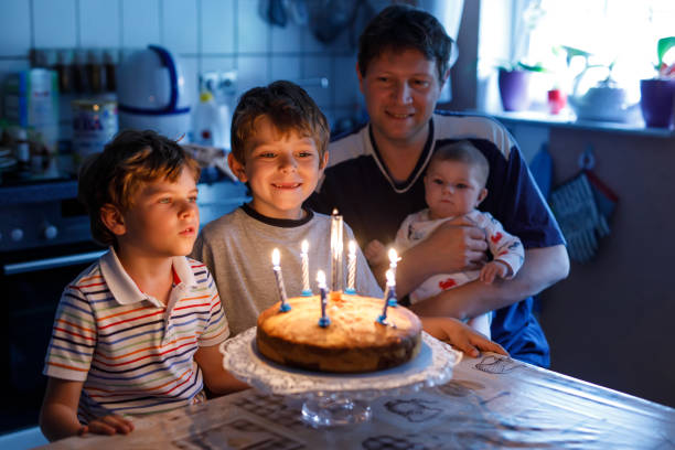 pequeno boy e família, pai, irmão e querida irmã comemorando aniversário - birthday cake family germany indoors - fotografias e filmes do acervo