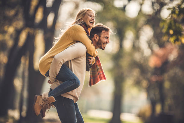 istock Cheerful couple having fun while piggybacking in autumn. 951634310