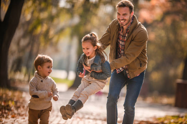 istock Happy single father having fun with his kids in autumn day. 951636336