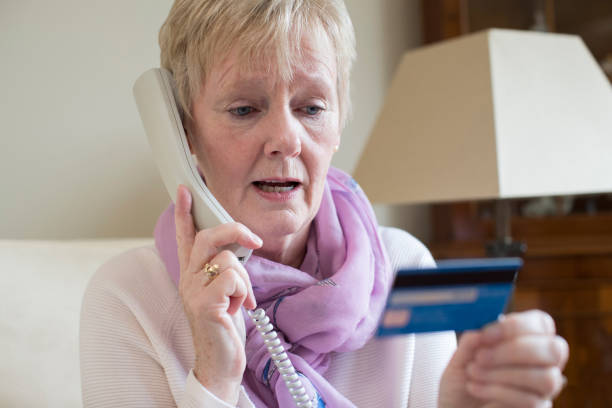 Senior Woman Giving Credit Card Details On The Phone Senior Woman Giving Credit Card Details On The Phone white collar crime photos stock pictures, royalty-free photos & images