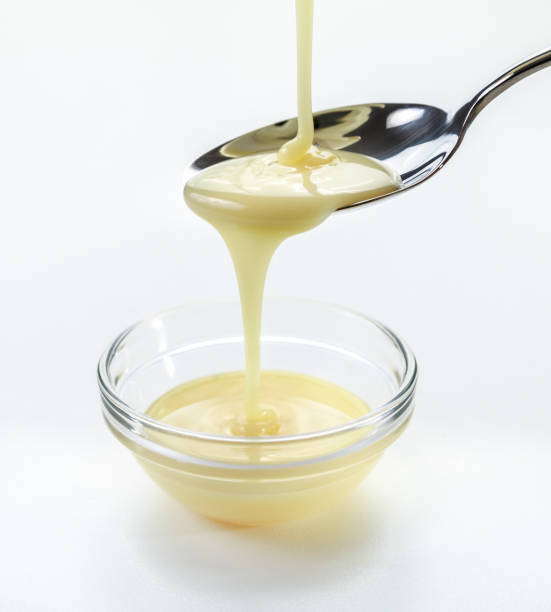 istock closeup pouring condensed milk with teaspoon on white background 951643374