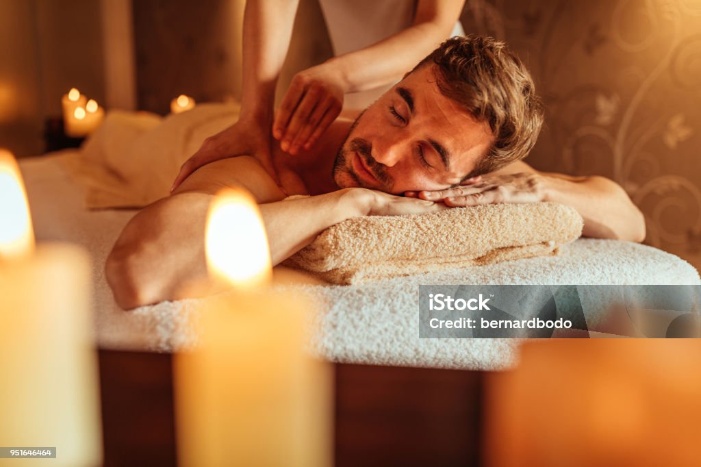 A stress free day Young man enjoying a massage at a spa Massaging Stock Photo