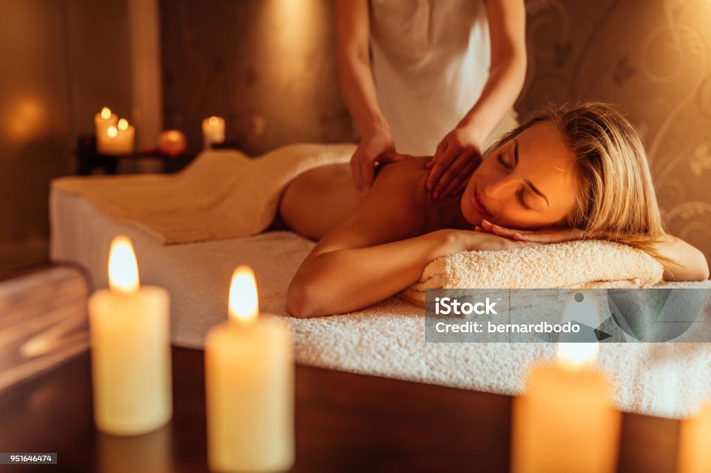 Soaked up in the serenity Young woman enjoying a massage at a spa Spa Stock Photo