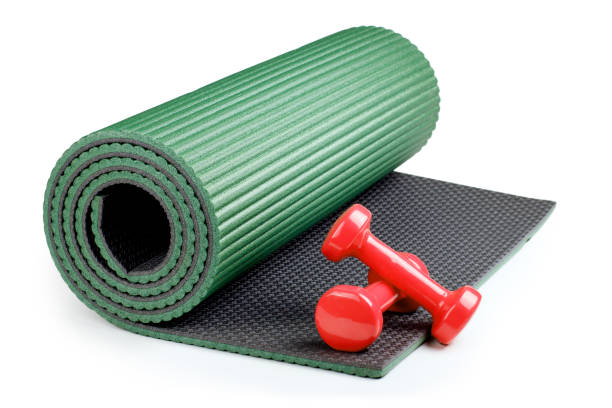 istock Yoga mat with dumbbells isolated on white background 951646486