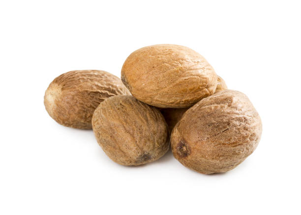 noce moscata isolata su sfondo bianco - nutmeg india spice nut foto e immagini stock