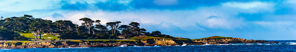 Pebble Beach, California, February 17, 2018:  Panorama view of Fan shell Beach with the Cypress Point Golf Course in the background.