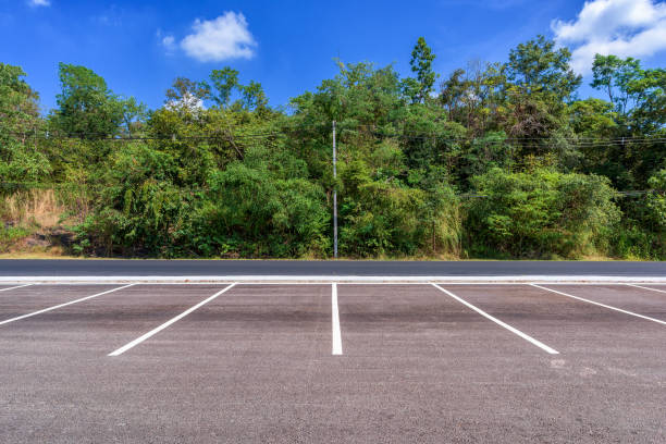 istock Empty parking lot with forest and beautiful blue sky. 951652704