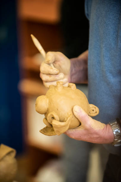 istock Mature artist moulding raw clay in art studio 951653904