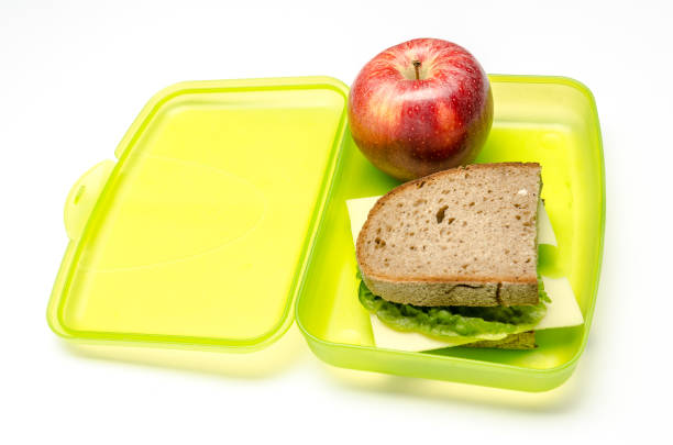istock green lunchbox with bread and apple on white background, isolated 951654948