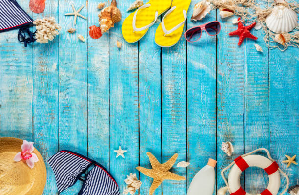 istock Beach accessories placed on blue wooden planks, top view. 951655370
