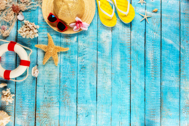 istock Beach accessories placed on blue wooden planks, top view. 951655442