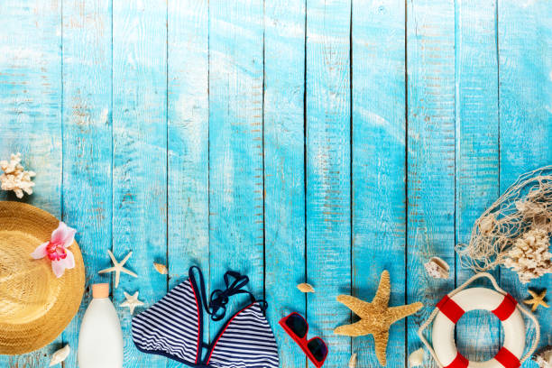 istock Beach accessories placed on blue wooden planks, top view. 951655598