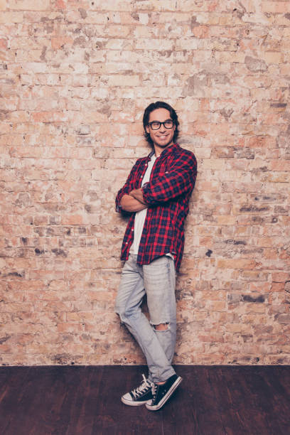 istock Handsome stylish young man standing near brick wall 951655866