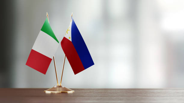 istock Italian And Philippines Flag Pair On A Desk Over Defocused Background 951656258