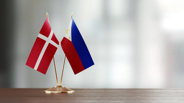 istock Danish And Philippines Flag Pair On A Desk Over Defocused Background 951656408